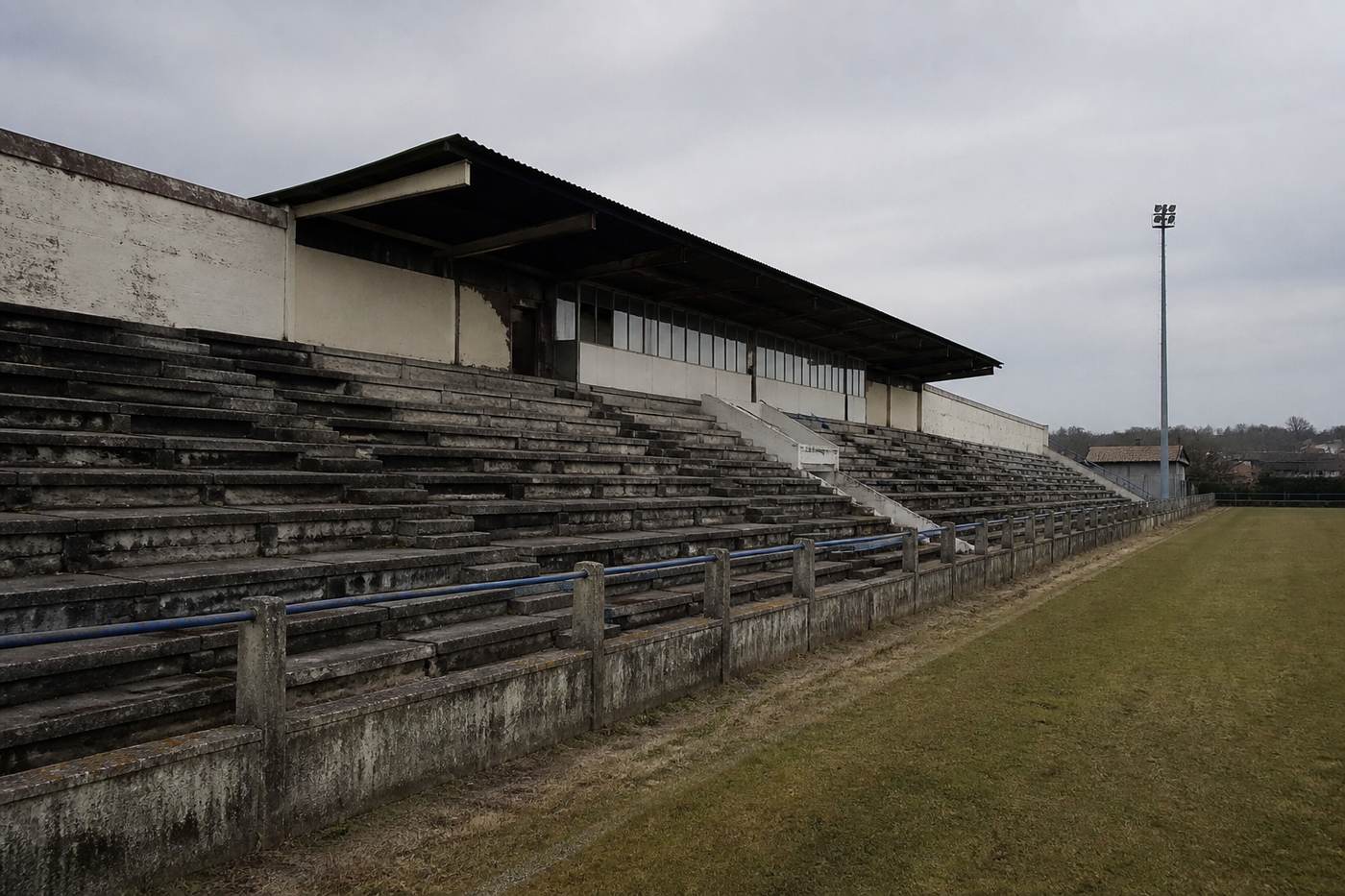 Tribună goală și teren de fotbal, fără persoane identificabile.